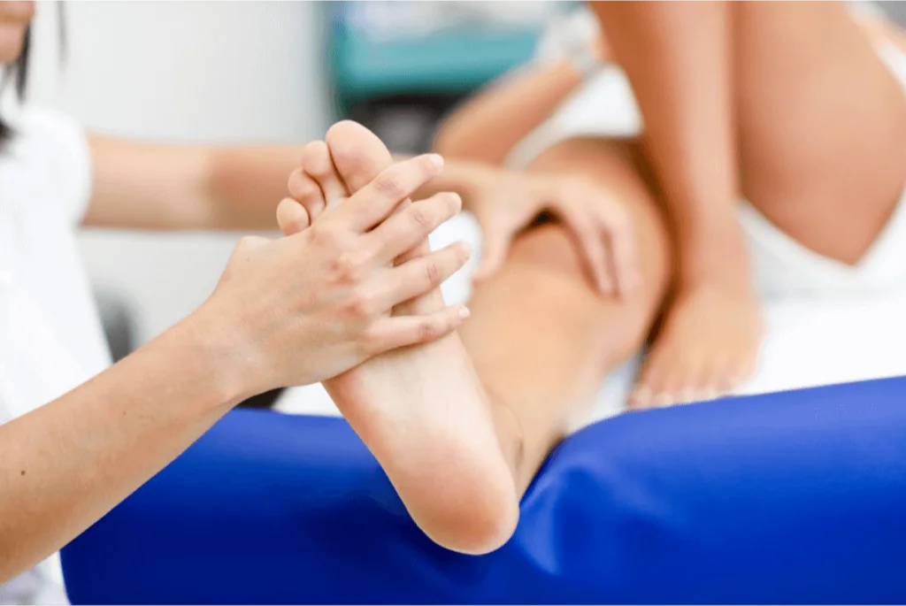 Healthcare practitioner providing foot therapy to a patient, addressing pain or sensitivity.