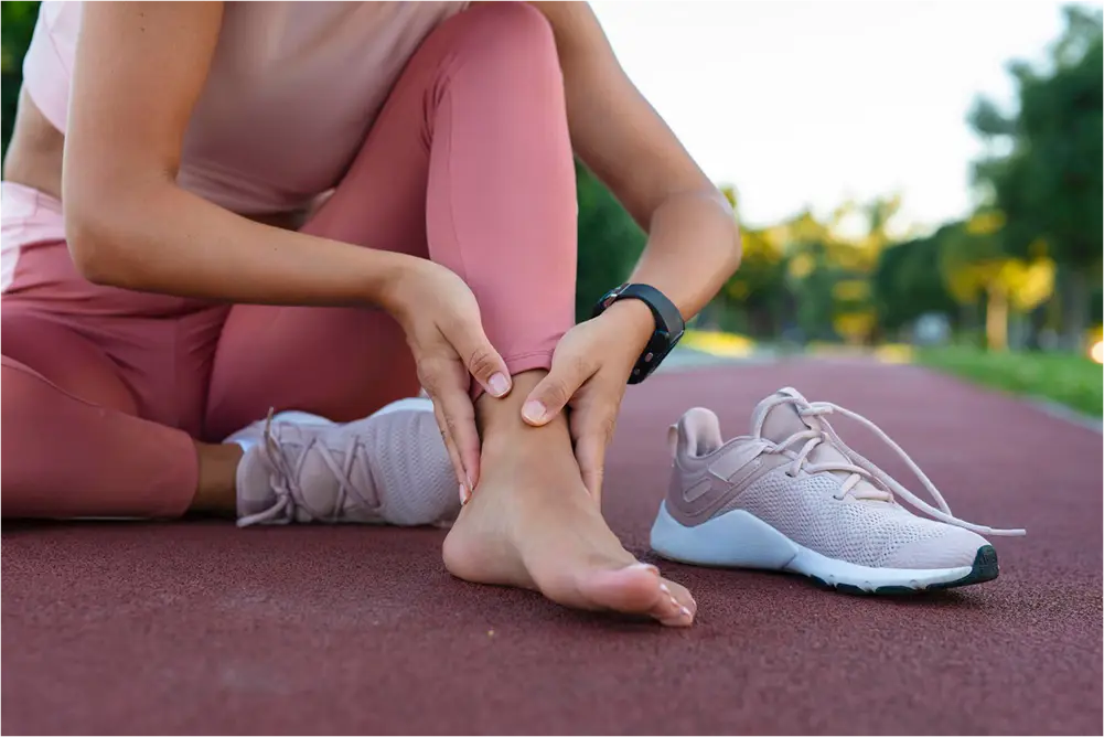 Person massaging ankle after exercise.