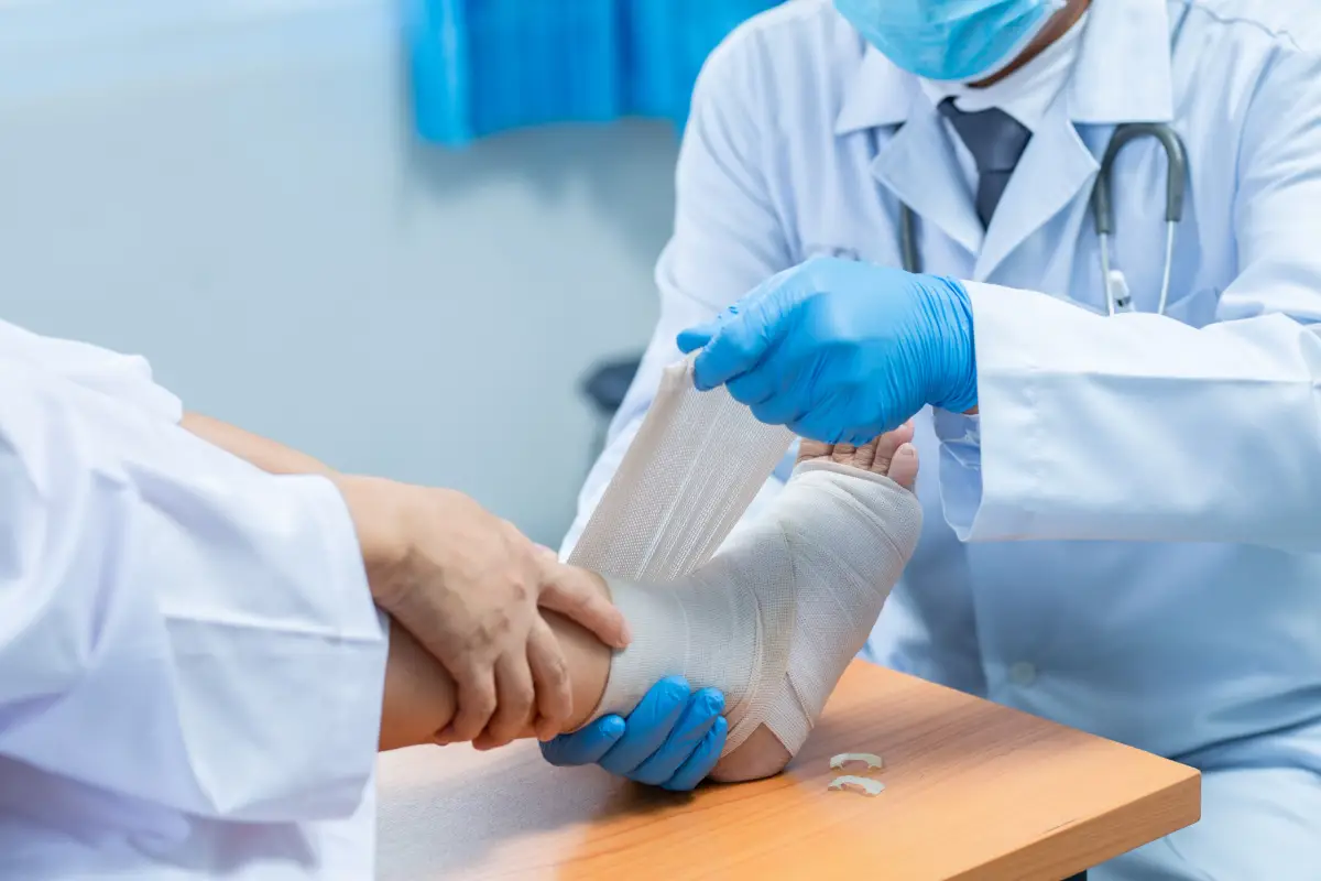 Close-up hand wear medical gloves Of Doctor Hand Tying Bandage On The Leg Of Patient.