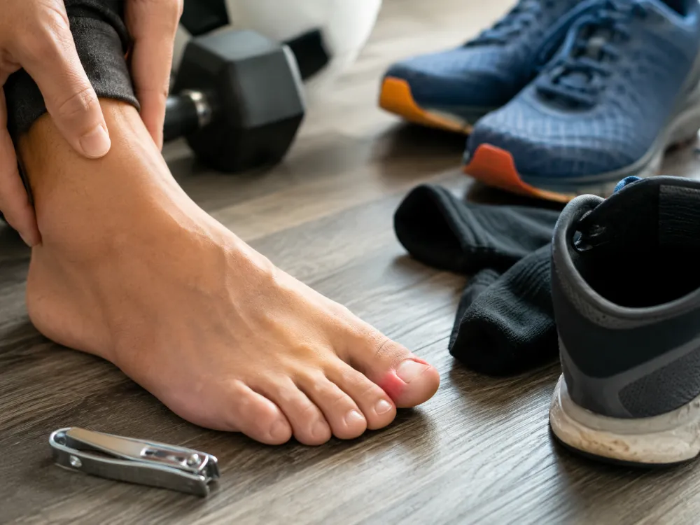 Sore toe beside tight shoes and nail clippers